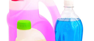 Bottles with different colored cleaning products in them. 