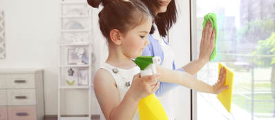 Girl helping her mother clean windows