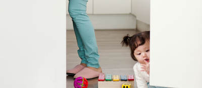 Child playing with toys on the kitchen floor.  