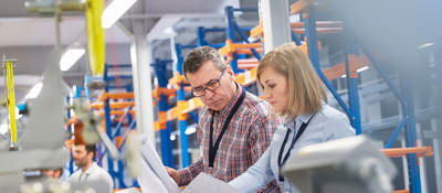 Two people at work looking at printed plans