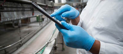 People collaborating on a tablet in a warehouse 