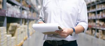 Man checking items on a clipboard in a warehouse