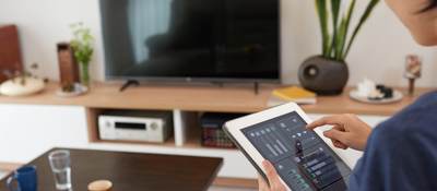 Woman controlling a smart home system with a tablet 