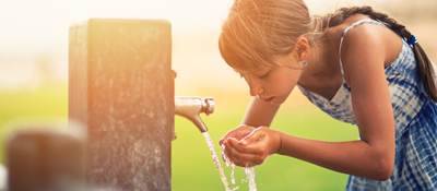 Girl drinking water from fountain