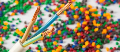 Plastic coated wire cable with plastic polymer granules in the background