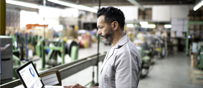 Technician using laptop while working in a factory