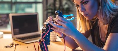 Person working in a robotics workshop