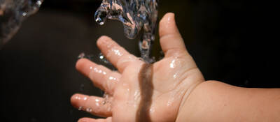 Baby holding hand under running water