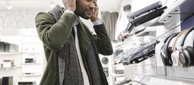 Man trying on headphones in a store.