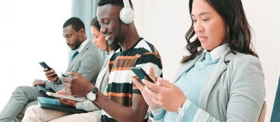 Several people in a waiting room and working on their smartphones