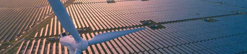 Wind turbines over a solar panel field