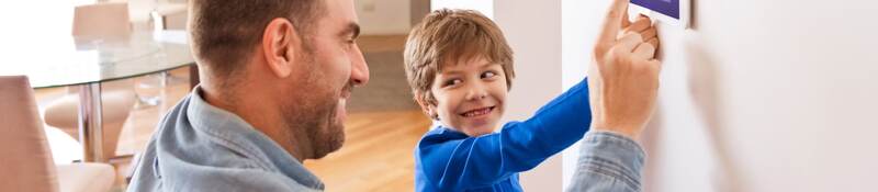 Father and his child are touching a IoT device.