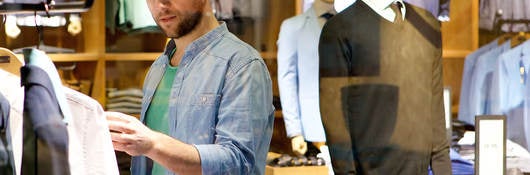 A man browses different articles of clothing.