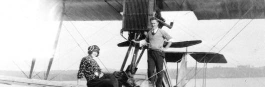 Two passengers enjoy a seaplane that bears a UL Registration Mfark, ca. 1922. | 