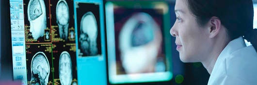 Woman in front of screen with medical scans  