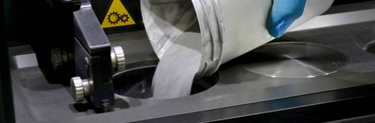 Man pours metal powder into the chamber of a laser sintering machine. 