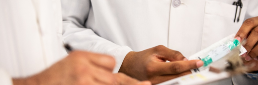 Men in a labcoat doing testing