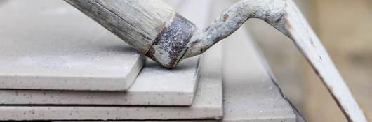 A trowel rests casually on a stack of cement tiles.