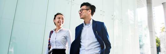 Asian business people discussing while walking