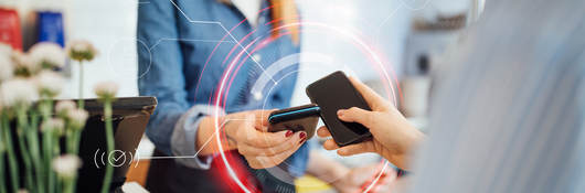 Woman tapping smartphone with another smartphone for payment