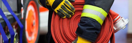 Photo of a firefighter holding a firehose