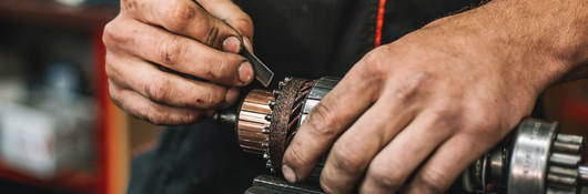 Manual worker repairing electric motor in a workshop