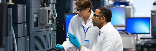 Laboratory technicians using specialized equipment for measuring chemicals