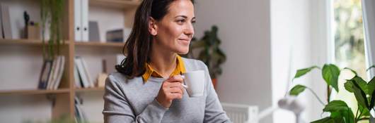 Person in home office setting, with a cup of coffee