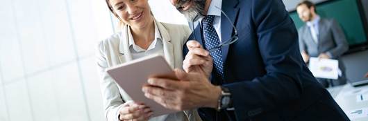 Two coworkers looking at a tablet