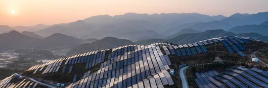 Aerial view of the solar power plant on the top of the mountain at sunset