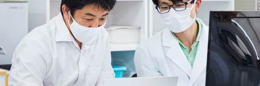 Life science researchers examining data on a laptop computer. 