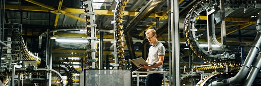 Engineer with laptop in a factory