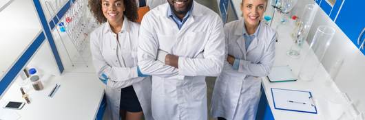 African American Scientist With Group Of Researchers In Modern Laboratory Happy Smiling, Mix Race Team Of Scientific Researchers In Lab.