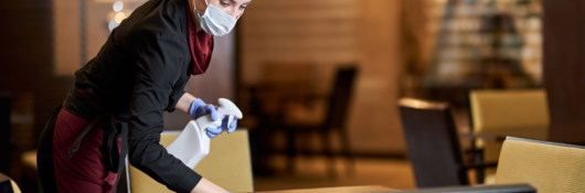 Waitress in uniform cleaning restaurant table