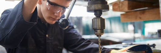 apprentice using pillar drill 