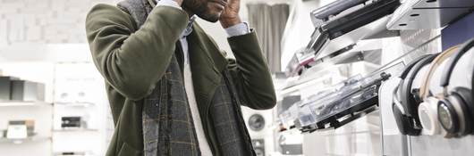 Man trying on headphones in a store.