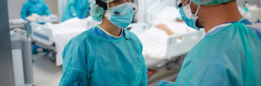 Two doctors talking and wearing PPE