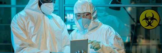 Two workers in a scientific laboratory discussing online clinical data