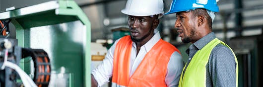 African Businessmen and Production Manager during meeting with production scheduling plan in a factory.