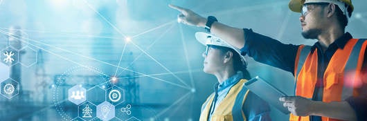 Male and female industrial engineers using tablet at power plant.