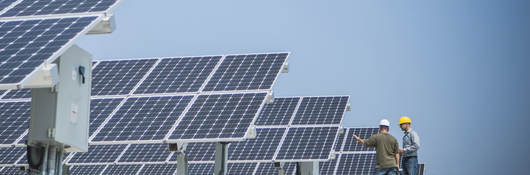 technicians talking near solar panels