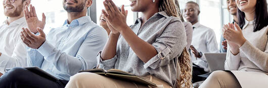 a group of businesspeople clapping hands during a conference