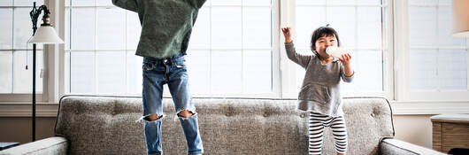 kids jumping on couch at home