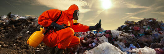 A person wearing orange protective equipment and measuring pollution