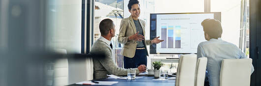 Three business colleagues reviewing metrics in a meeting