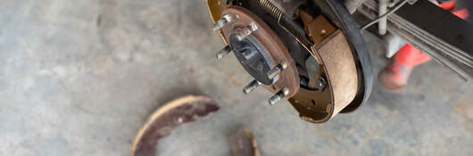 Drum brake and asbestos brake pads at car garage