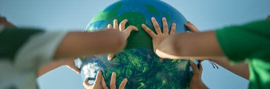 Children holding a planet outdoors