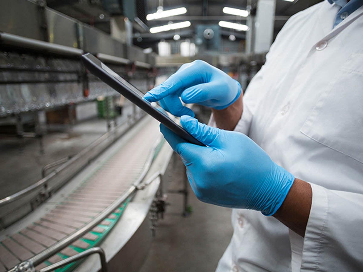 People collaborating on a tablet in a warehouse 