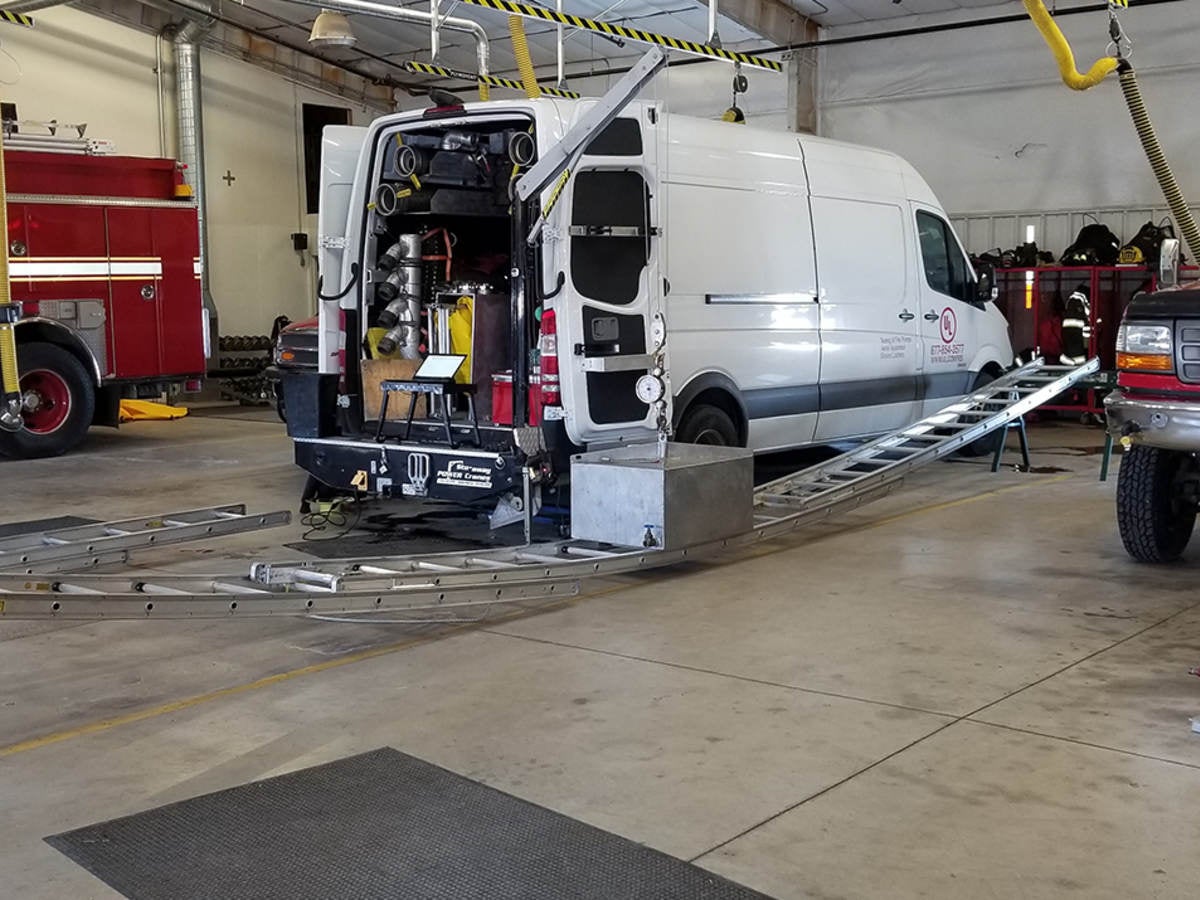 A ladder being tested bearing the weight of a heavy object in a fire department.