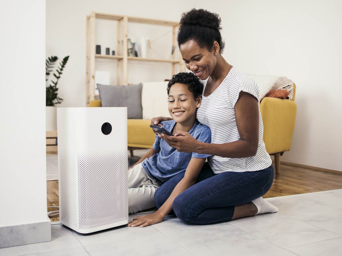 African American woman and her son setting up the intelligent home system on a smartphone.